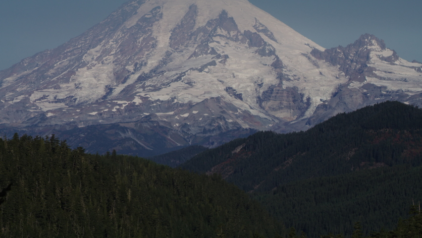 Tilt up to snow on mountain range under blue sky . Packwood, Washington, United States