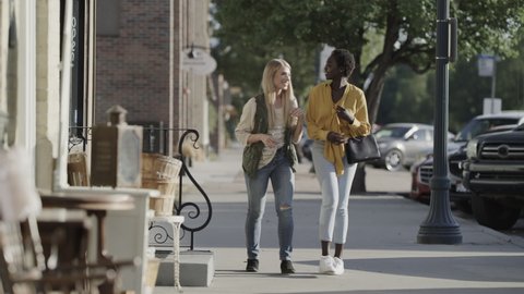 Slow motion of carefree women talking and laughing on city sidewalk . Pleasant Grove, Utah, United States