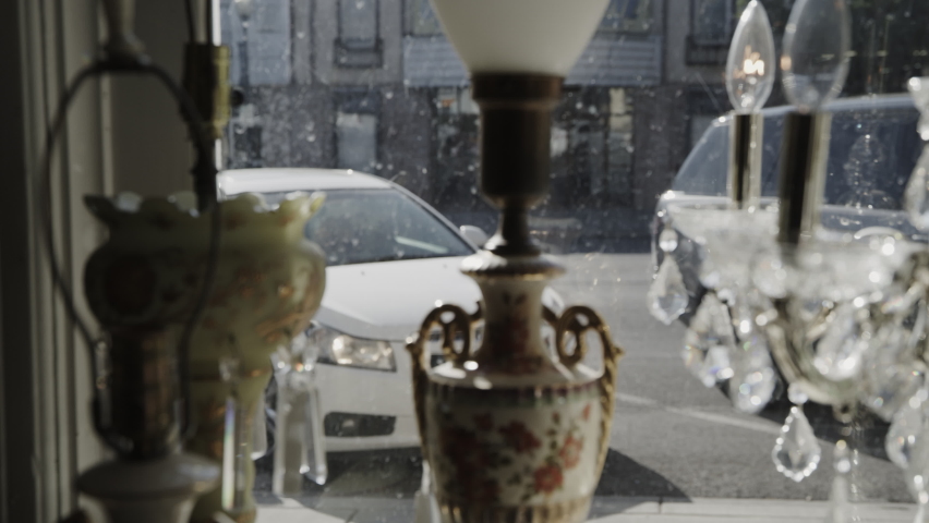 Women window shopping lamps then entering antique store . Pleasant Grove, Utah, United States
