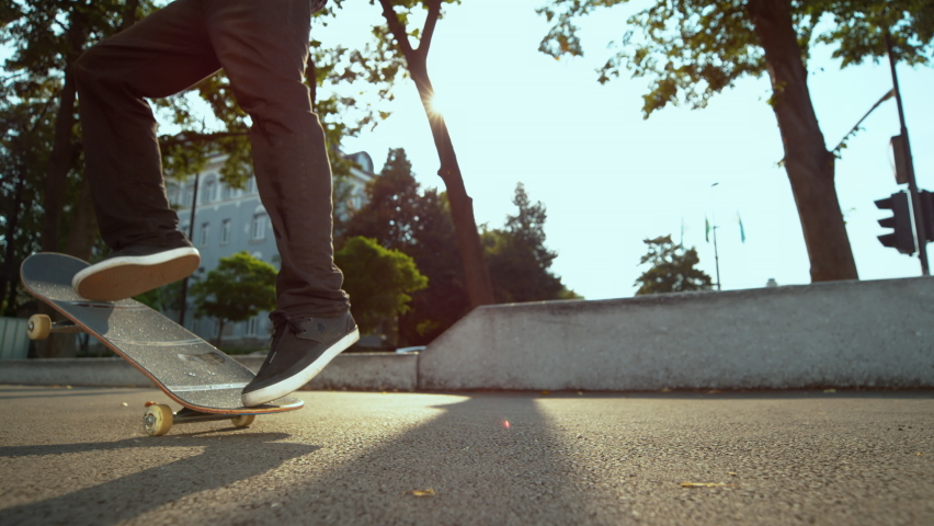 SLOW MOTION TIME WARP, LENS FLARE, CLOSE UP, LOW ANGLE, DOF: Skateboarder lands a nollie kickflip during freestyle session at an urban skate park. Unrecognizable man lands a trick while skateboarding | Shutterstock HD Video #1063265023