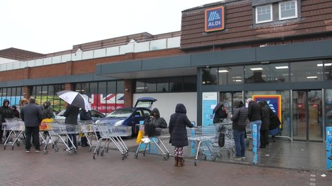 London , Sutton , United Kingdom (UK) - 03 19 2020: People are queueing outside of the supermarket chain Aldi before it is open in the morning to shop and stock up on food during the Corona virus cris