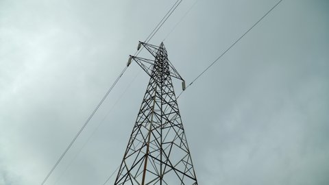 a metal lighting pole on a cloudy day from below
