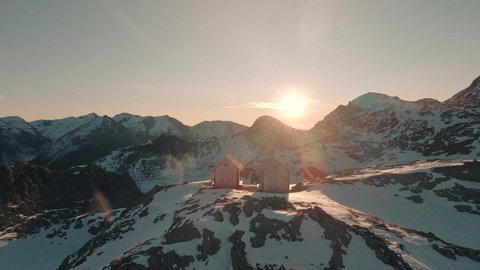 Drone flying over two cabins at sunrise. The Austrian Alps of East Tyrol.