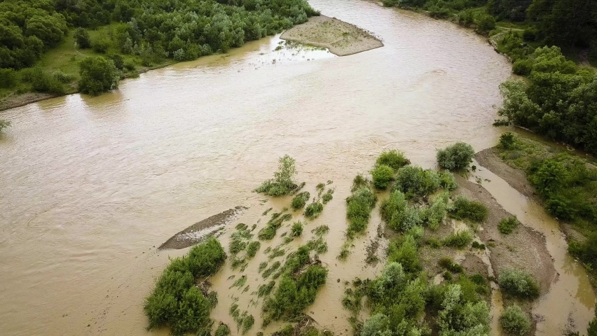 Wide dirty river in flooding period during heavy rains in spring.