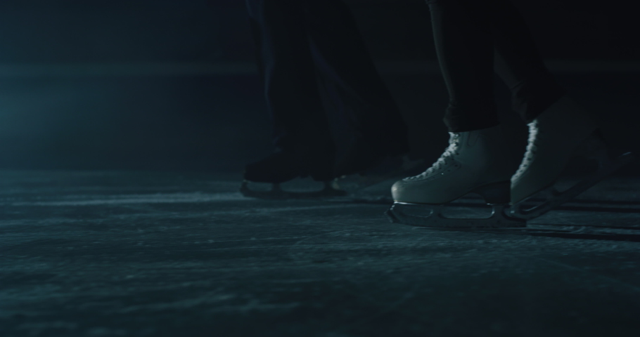 Cinematic close up shot of couple figure skaters skating shoes while performing a woman's single choreography on ice rink during a competition. Concept of perfection, precision, freedom, passion. Royalty-Free Stock Footage #1063296001