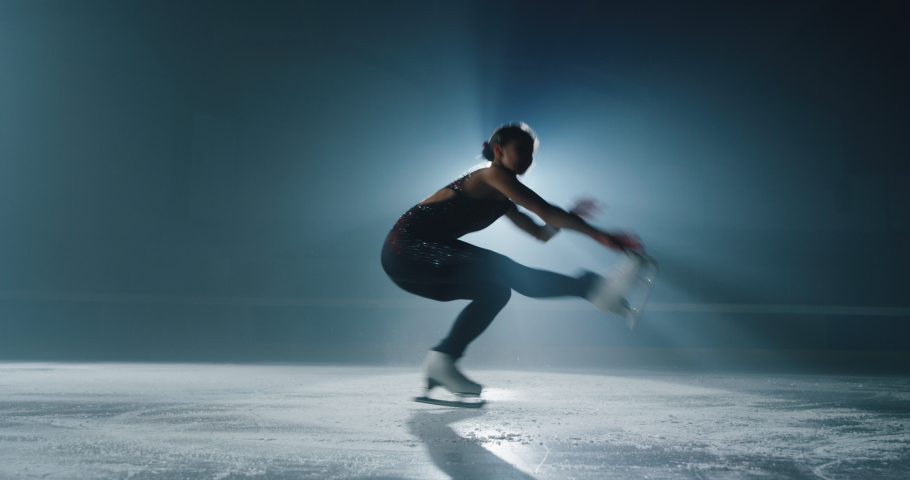 Cinematic shot of young female artistic figure skater is performing a woman's single skating choreography on ice rink before start of a competition. Concept of perfection, precision, freedom, passion. Royalty-Free Stock Footage #1063296169