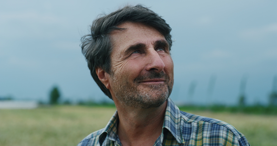 Cinematic shot of a mature male farmer satisfied with his work is enjoying a nature around him on a countryside farm fields. | Shutterstock HD Video #1063298002