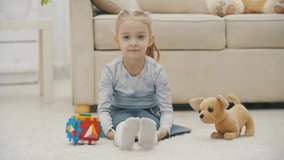 4k video of cheerful girl playing on floor.