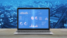 Statistics graphs, charts and diagrams data on modern laptop computer monitor screen on wooden table over city tower, street, expressway and skyscraper, Business financial intro motion background - Powered by Shutterstock - Get 15% off with code: PIKWIZARD15