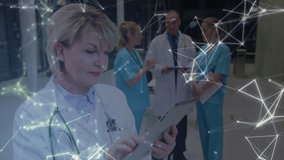 Animation of glowing network of connections against female doctor using tablet and male doctor and two female medical staff discussing at hospital. medicine research science and global networking - Powered by Shutterstock - Get 15% off with code: PIKWIZARD15