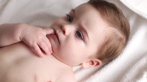 Portrait of a newborn baby, which Mom lubricates the child face with an allergy cream or other skin disease, a white spot on the skin of the child.