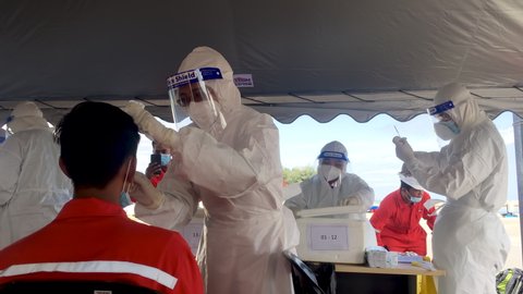 KOTA BHARU  KELANTAN, MALAYSIA - OCT 25 2020 : Unidentified medical staff with protection suit performed a nasal congestion swab from offshore crew to test for the coronavirus covid-19 infection.