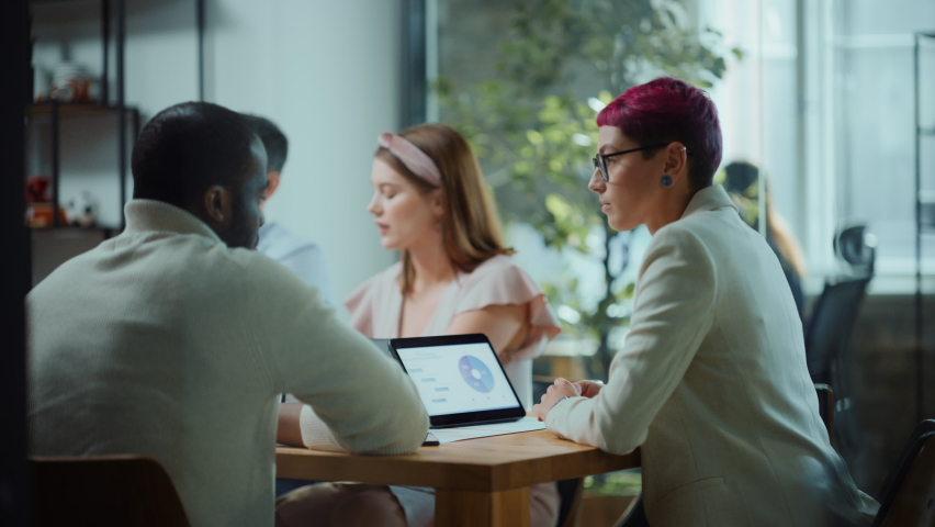 Diverse Multi-Ethnic Group of Professional Businesspeople Meeting in the Modern Office Conference Room. Creative Team Discuss App Design, Analyze Data, Plan Marketing Strategy, Disrupt Social Media Royalty-Free Stock Footage #1063309444