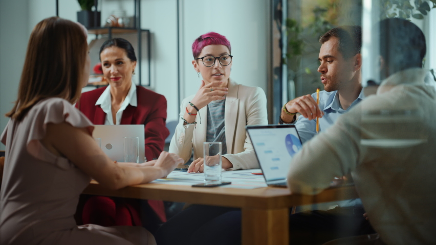 Office Meeting in Conference Room: Beautiful Specialist with Short Pink Hair Talks about Firm Strategy with Diverse Team of Professional Businesspeople. Creative Start-up Team Discusses Big Project | Shutterstock HD Video #1063309516