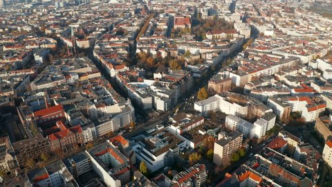 Typical Berlin Neighbourhood residential area in sunny daylight with view on Red rooftops and main Street, Aerial Wide Establishing Shot