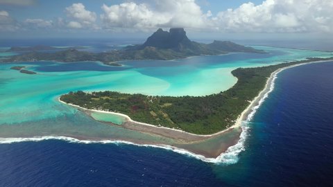 Drone aerial view Bora Bora Tahiti, 4k. Tropical paradise island, turquoise crystal clear water lagoon. French Polynesia. Exotic travel vacation getaway, romantic honeymoon destination.