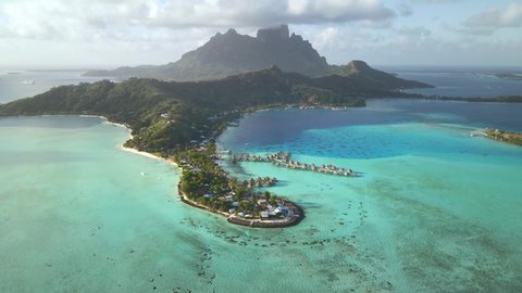 Drone aerial view Bora Bora Tahiti 4k. Romantic exotic destination. Overwater bungalow villas, turquoise lagoon. French Polynesia. Luxury honeymoon vacation.