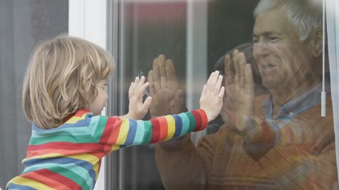 Old man indoor play with child outdoor, touch hand through window, waving hands, kiss, sad quarantine isolation, prison, lock down, free love