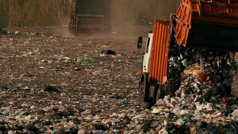 Trash is poured out of the garbage truck copy space. Damage to the environment. Pollution concept. Landfill in slow motion.