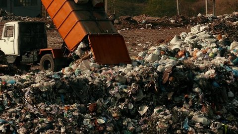 Garbage bags are poured out of the garbage truck. Damage to the environment. Pollution concept. Landfill in slow motion.