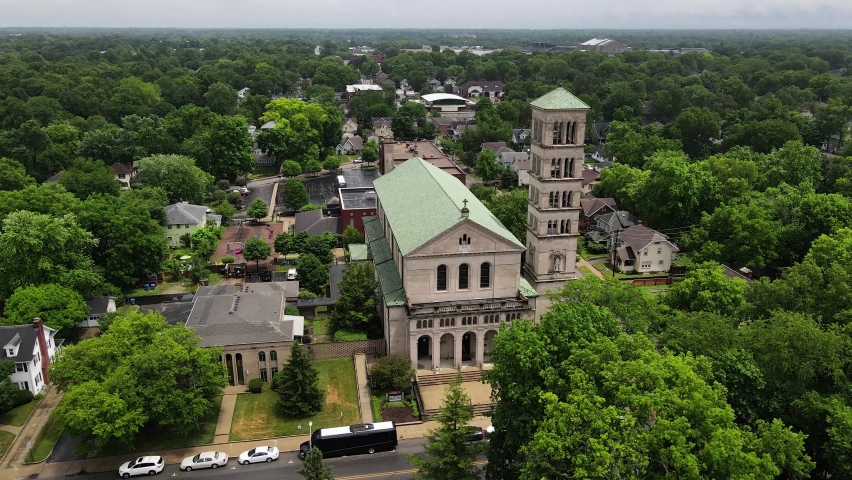 Aerial View of Saint Joan of Arc Catholic Church in Indianapolis, Indiana, USA. Religious Landmark and Green Tree Lush on Summer Day