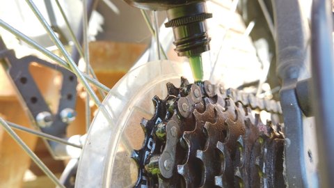 Closeup shot of a bike chain being oiled.