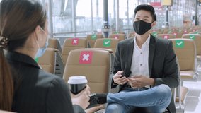 New normal and social distancing concept.Businessman and businesswoman wearing face mask meeting during airline flight status and sitting with distance during coronavirus 2019 outbreak at airport - Powered by Shutterstock - Get 15% off with code: PIKWIZARD15