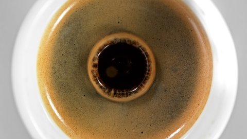 Super Slow Motion Detail Shot of Coffe Drop Falling into Fresh Espresso at 1000 fps.