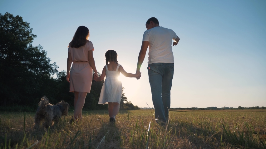 Happy friendly family park. Silhouette of family at sunset park. Friendly parents, baby walk together dog. child with his parents at sunset enjoying walk. Silhouette of friendly people in nature. Royalty-Free Stock Footage #1063354339
