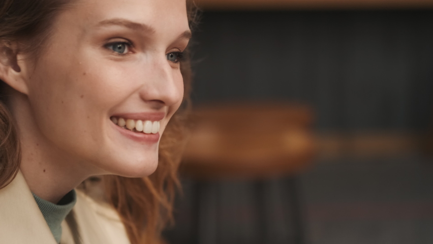 Conceptual shot of pretty smiling student girl paying by credit card online purchases using laptop in street cafe
