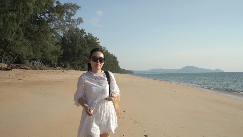 Young mother walking on the beach with her daughter in Phuket.