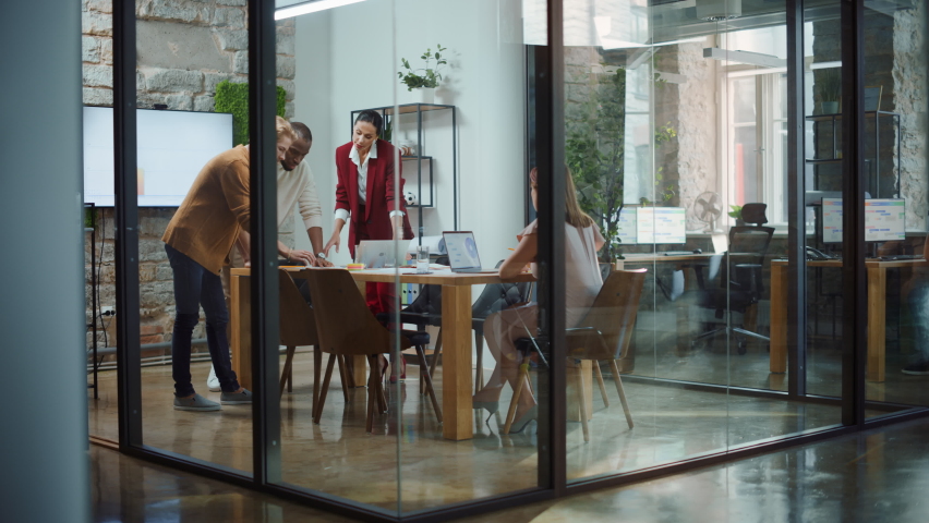 In the Stylish Modern Office Meeting Room: Diverse Group of Business Growth Marketing Professionals Use Computers, Discuss Project Ideas, Brainstorm Startup Company Strategy, Design Creative Product Royalty-Free Stock Footage #1063359157
