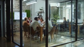 Diverse Group of Professional Businesspeople Meeting in the Modern Office Conference Room. Creative Team Discuss App Design, Analyze Data, Plan Marketing Strategy, Disrupt Social Media, Growth Hack - Powered by Shutterstock - Get 15% off with code: PIKWIZARD15