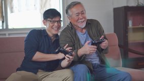 Senior asian father and middle aged son playing video game together in living room, Happiness Asian family concepts