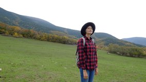 Beautiful asian woman in plaid shirt and hat on the background of autumn forest .