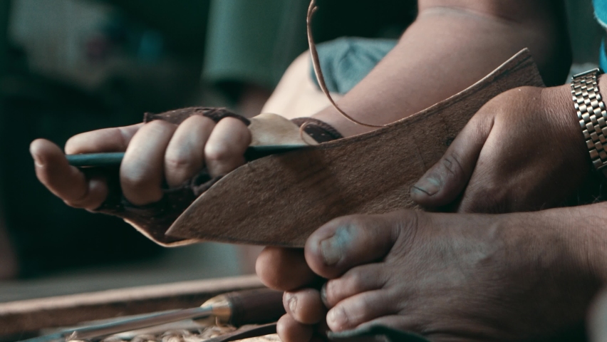 Nepalese craftsman cutting away a small wooden piece