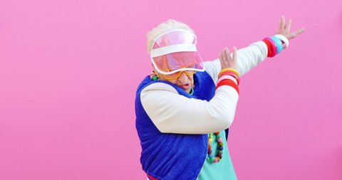  Footage of a funny grandmother with fashionable look acting on colored backgrounds