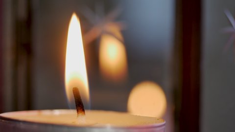 close up view footage of igniting a candle in the dark, candle position on the left of the frame. Cozy home interior decor, burning candles hygge, decoration and christmas concept - candles burning