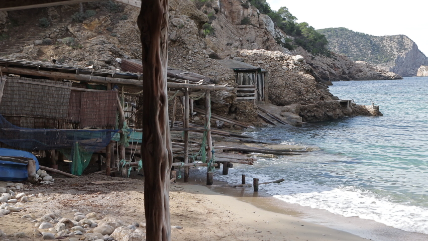 Cinematic view of an old boat house by the ocean. Wooden boat house on a tropical beach in Ibiza.
