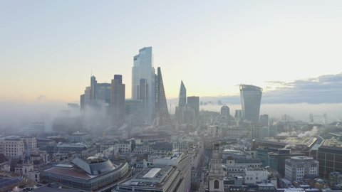 Establishing aerial slider shot of London Central business district foggy sunrise