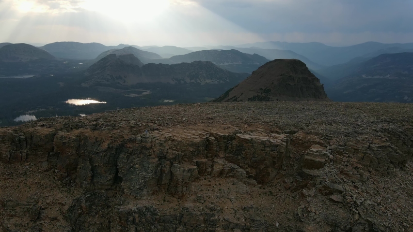 Aerial view Ascending shot, Scenic view of the summit of King’s Peak in Uinta Mountain range in Utah, Sun light in the background.