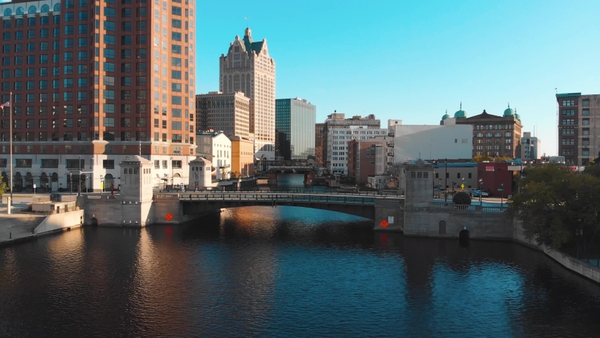 Descending aerial shot of river and bridges in downtown Milwaukee, WI