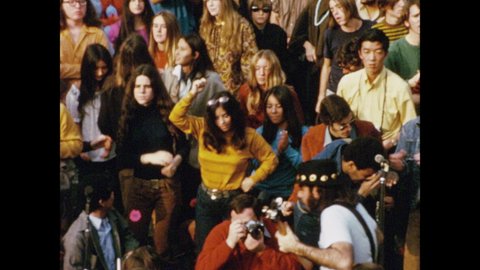 1970s: Rock band performs before crowd in Griffith Park, Los Angeles, as audience members clap and dance.