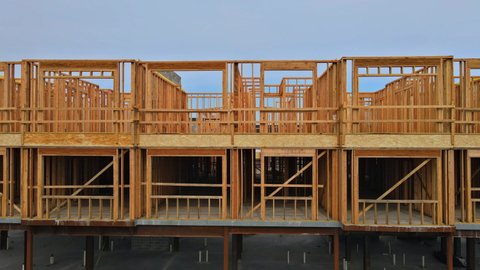 Wood home framing at construction site with wooden truss framework