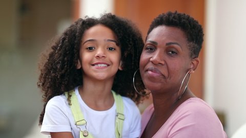 Mother and child posing together, mixed race black african ethnicity mom and daughter.