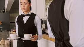 4k wide steadicam video of waiter and coffee on a tray, walking to a customer in hotel or restaurant cafe. 