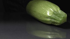 Organic zucchini close-up. Black background. Fresh vegetables.