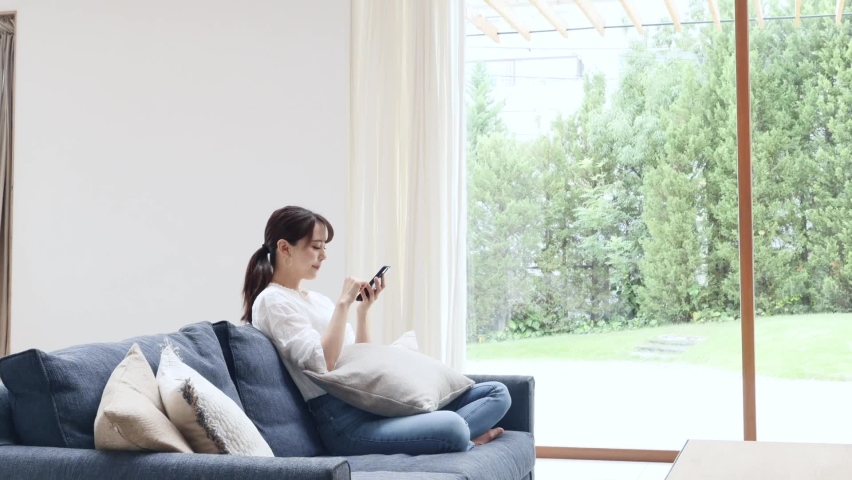 Asian women using the smartphone on the sofa