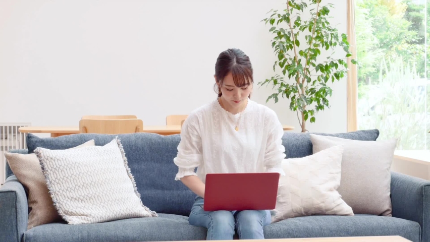 Asian women using the laptop on the sofa Royalty-Free Stock Footage #1063392802