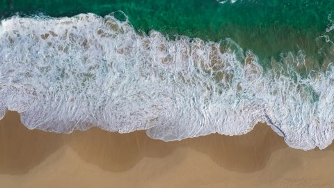 Top view of crystal clear sea and sand beach 4k video stock footage. Looping Water surface texture landscape. Aerial view ocean waves. Seaside sand. Sunset water seamless loop background.